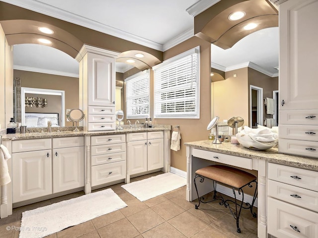 bathroom featuring double vanity, tile patterned flooring, baseboards, and ornamental molding