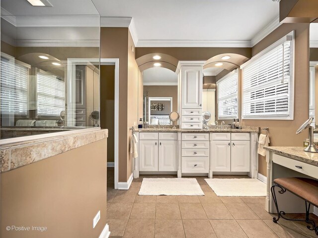 full bathroom with a shower with door, baseboards, ornamental molding, double vanity, and tile patterned floors