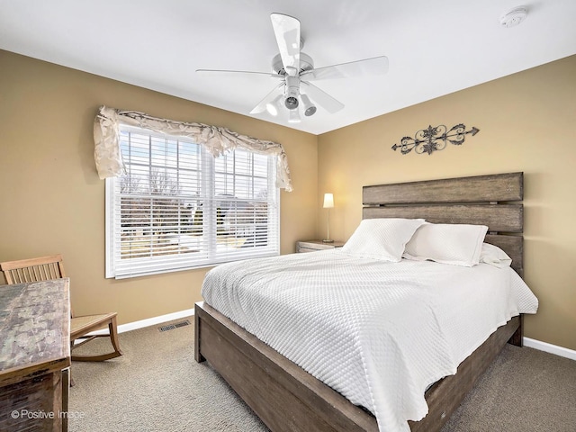 carpeted bedroom with visible vents, a ceiling fan, and baseboards