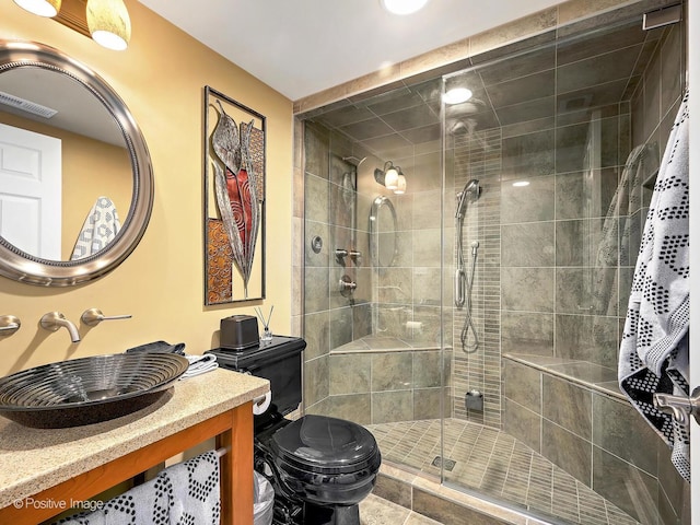 bathroom featuring visible vents, a stall shower, toilet, and vanity