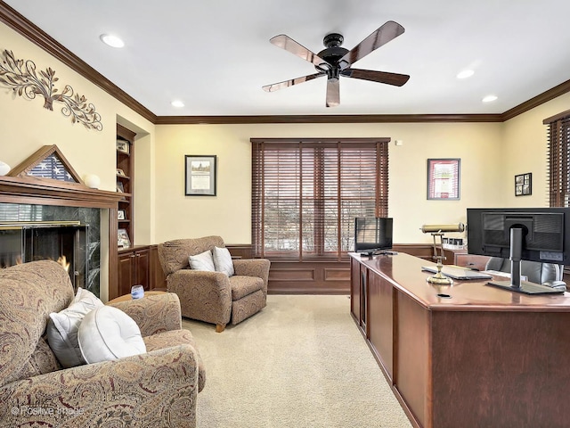 office space featuring a wainscoted wall, built in shelves, light carpet, and crown molding