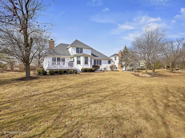 view of front of property featuring a front lawn, a chimney, and a deck