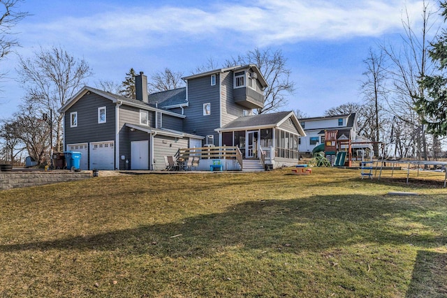 back of property with a sunroom, a chimney, a garage, a playground, and a trampoline