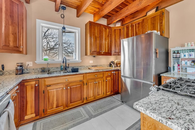 kitchen featuring a sink, wood ceiling, brown cabinetry, and freestanding refrigerator