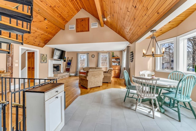 dining room with visible vents, a brick fireplace, and wooden ceiling