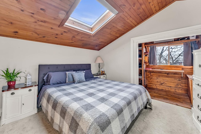 bedroom with vaulted ceiling with skylight, light colored carpet, and wood ceiling