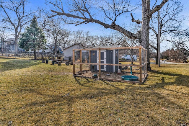 view of yard featuring an outdoor structure, exterior structure, and fence