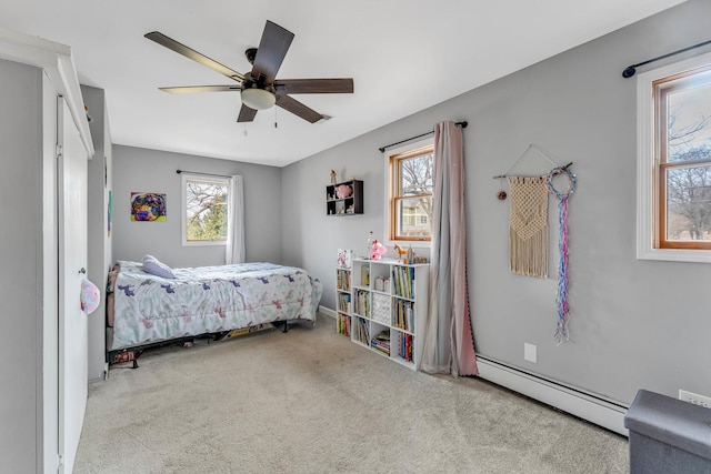 bedroom with a baseboard radiator, carpet floors, multiple windows, and a ceiling fan