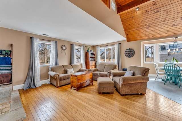 living area featuring plenty of natural light, baseboards, light wood-type flooring, and visible vents