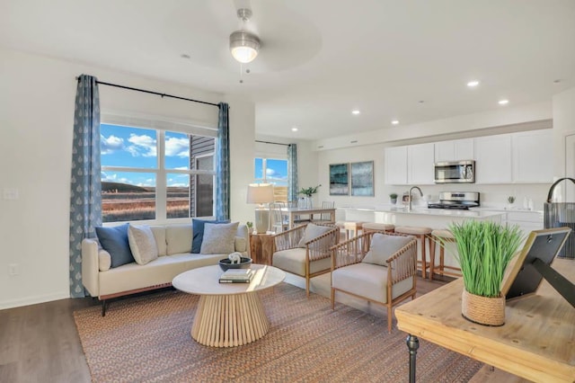 living room featuring recessed lighting, baseboards, wood finished floors, and a ceiling fan