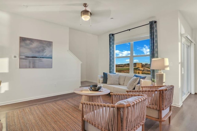 living room with a ceiling fan, wood finished floors, and baseboards