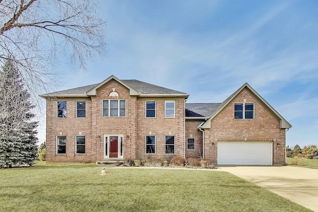 colonial inspired home featuring a front yard, an attached garage, brick siding, and driveway