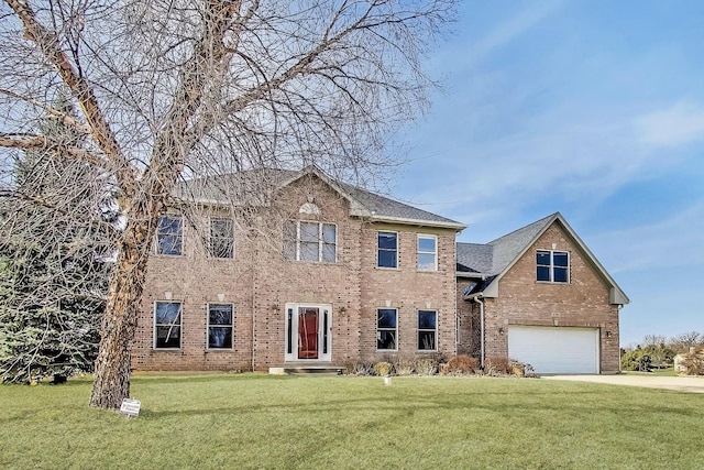 colonial house with a front yard, a garage, brick siding, and concrete driveway