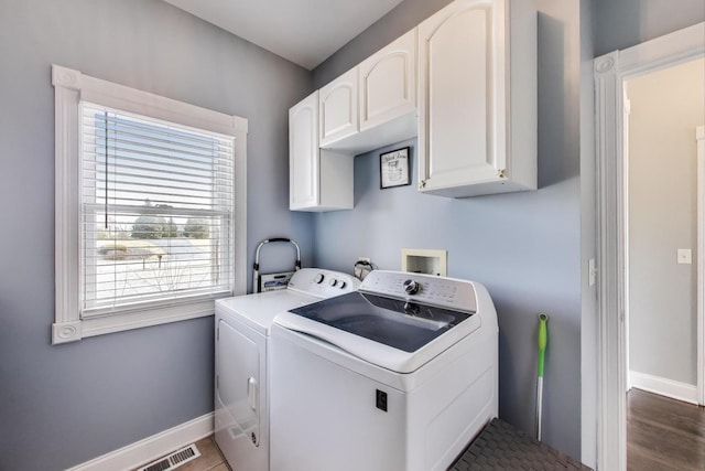 laundry area with baseboards, cabinet space, visible vents, and washer and clothes dryer