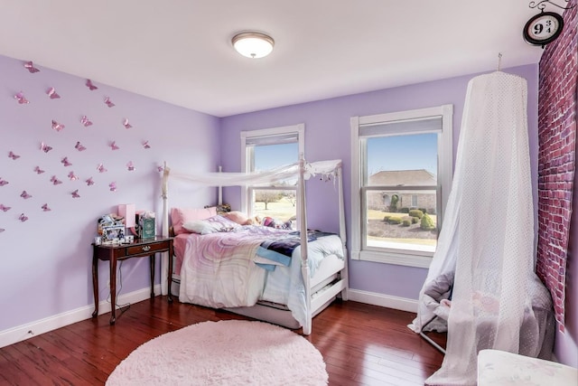 bedroom with baseboards and wood-type flooring