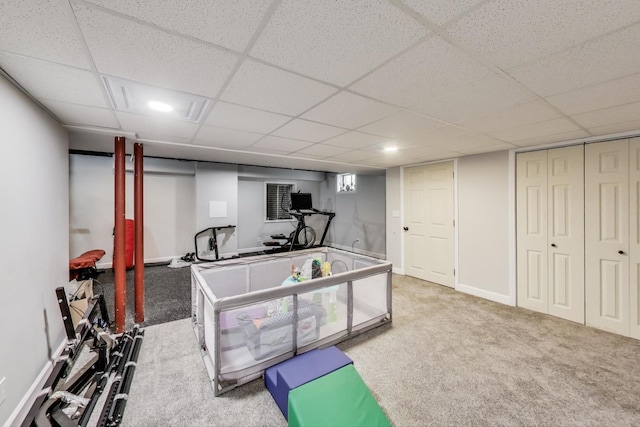 recreation room with a paneled ceiling, baseboards, and carpet flooring