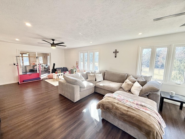 living area with a healthy amount of sunlight, ceiling fan, and dark wood-style flooring