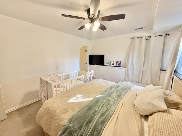 carpeted bedroom featuring visible vents, baseboards, and ceiling fan