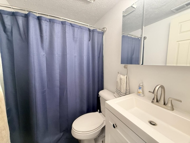 full bath with vanity, toilet, visible vents, and a textured ceiling