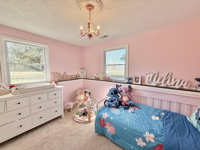 bedroom featuring visible vents, a textured ceiling, an inviting chandelier, and carpet flooring