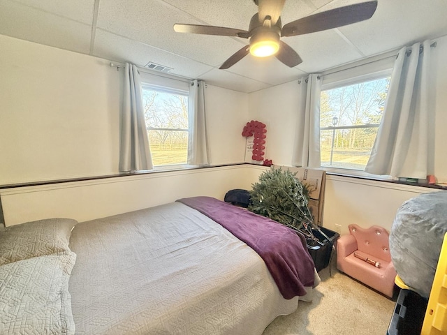 carpeted bedroom featuring visible vents and ceiling fan