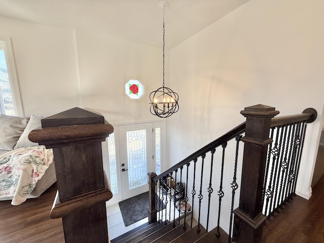 foyer entrance featuring a wealth of natural light, a notable chandelier, and wood finished floors