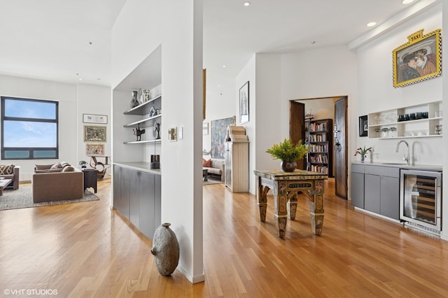 680 N Lake Shore Dr Unit 1602, Chicago, IL 60611 - hallway with wine cooler, light wood finished floors, a sink, a towering ceiling, and recessed lighting