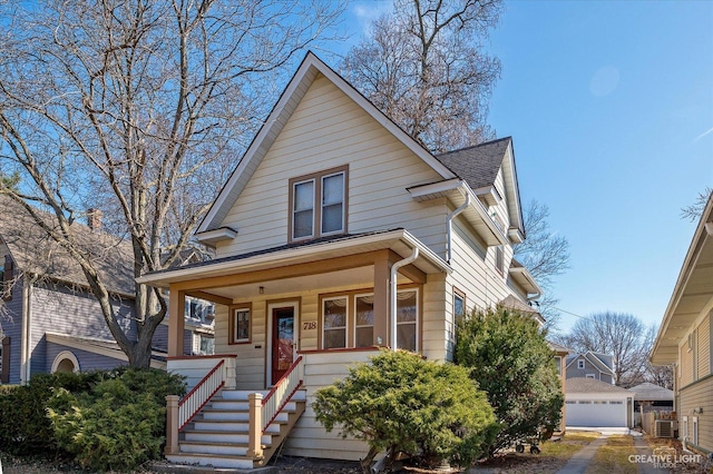 view of front facade featuring an outbuilding, covered porch, central AC, and roof with shingles