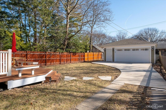 view of yard with a wooden deck, a detached garage, an outdoor structure, and fence