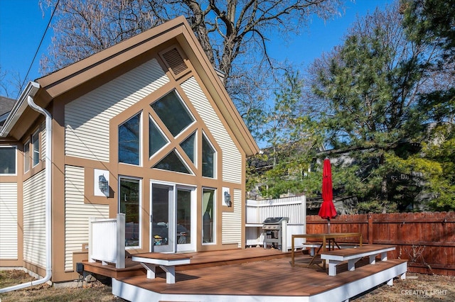 back of property featuring a wooden deck and fence