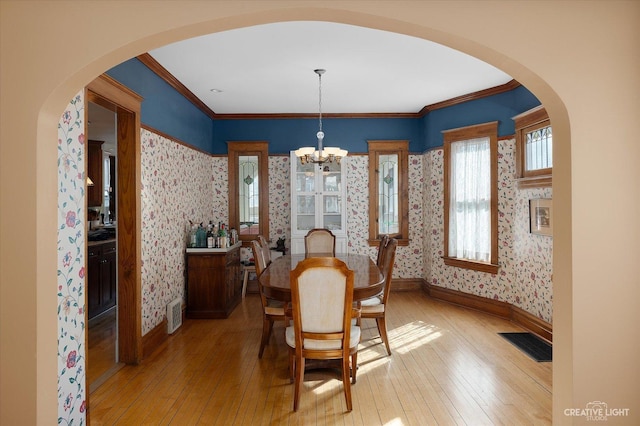 dining area featuring visible vents, wood-type flooring, baseboards, and wallpapered walls