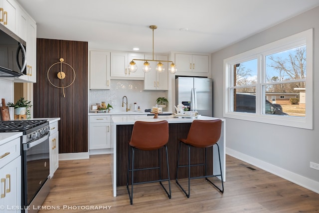 kitchen featuring visible vents, backsplash, appliances with stainless steel finishes, and light countertops