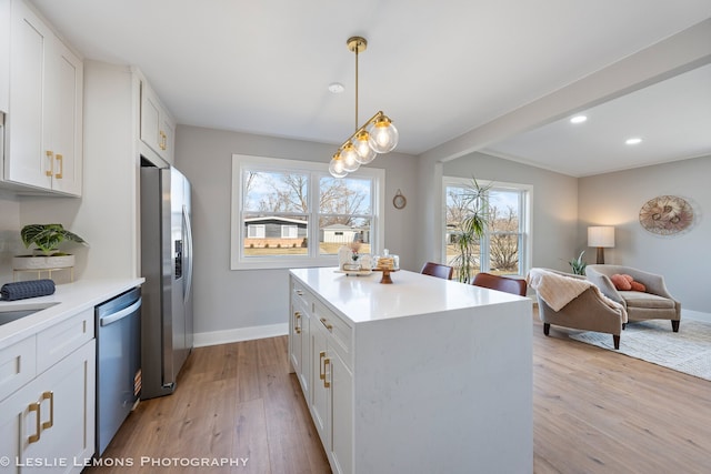 kitchen featuring light wood-type flooring, stainless steel appliances, white cabinets, light countertops, and baseboards