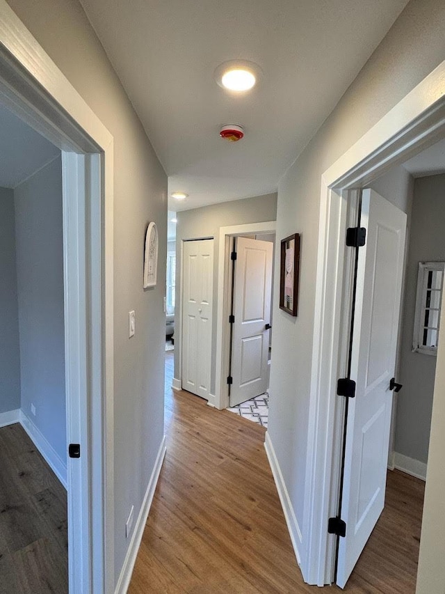 hallway featuring baseboards and wood finished floors