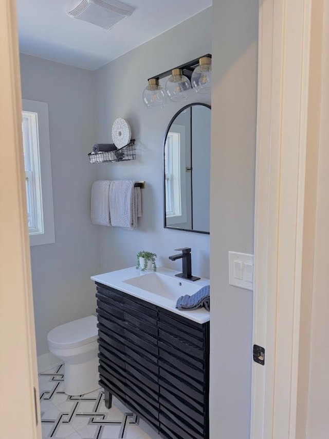 half bathroom with visible vents, toilet, and vanity