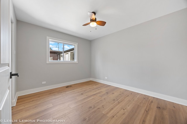 empty room featuring a ceiling fan, light wood-style floors, and baseboards