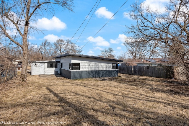 back of house with a yard and fence