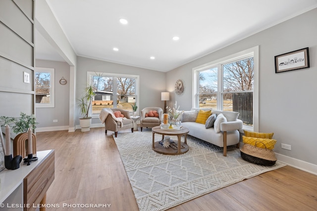 living room featuring recessed lighting, baseboards, and light wood finished floors