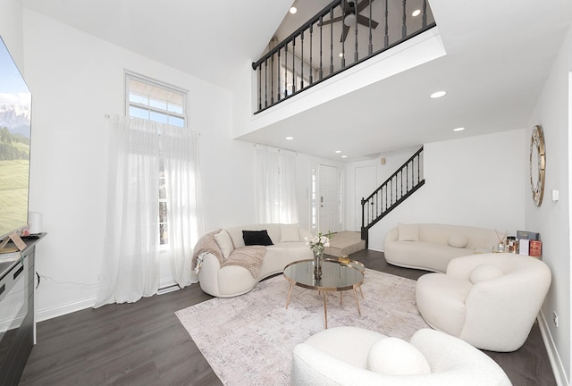 living room featuring dark wood finished floors, recessed lighting, stairway, baseboards, and a towering ceiling