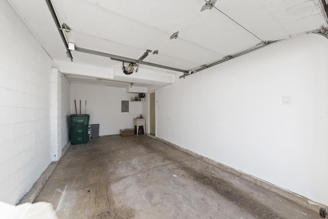 garage featuring electric panel, concrete block wall, and a sink