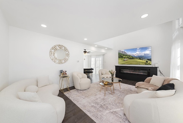 living room featuring a glass covered fireplace, recessed lighting, and wood finished floors