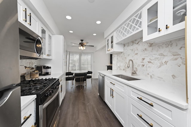 kitchen featuring dark wood-style floors, ceiling fan, a sink, light countertops, and appliances with stainless steel finishes