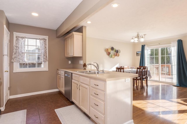 kitchen with a wealth of natural light, dishwasher, a peninsula, and a sink