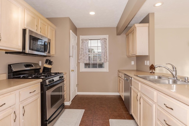 kitchen featuring a sink, stainless steel appliances, dark tile patterned floors, and light countertops