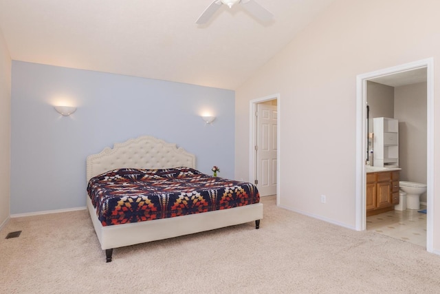 bedroom with baseboards, visible vents, ensuite bath, vaulted ceiling, and light carpet