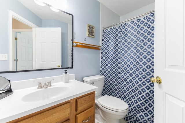 bathroom with curtained shower, toilet, and vanity