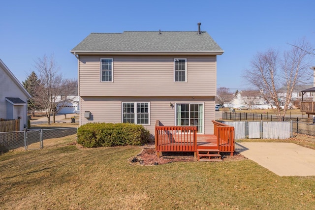 back of property with a deck, a yard, a fenced backyard, and a shingled roof