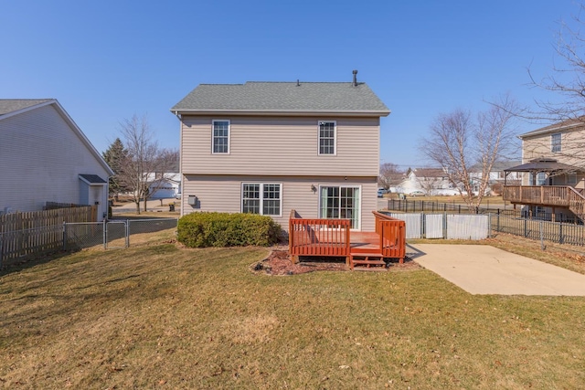 back of house featuring a deck, a lawn, and a fenced backyard