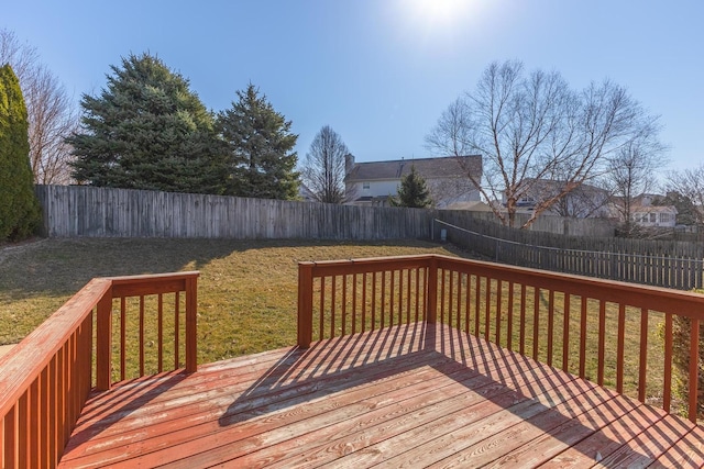 wooden terrace with a lawn and a fenced backyard