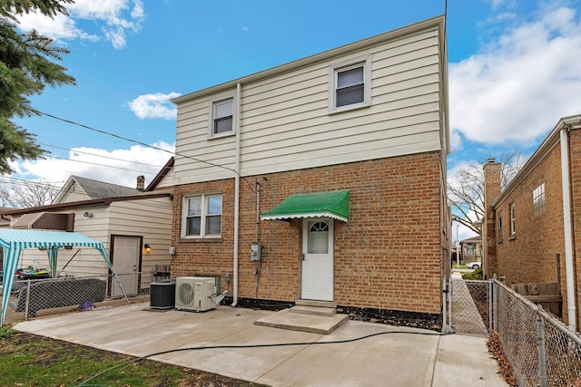 back of house featuring central air condition unit, fence, and brick siding